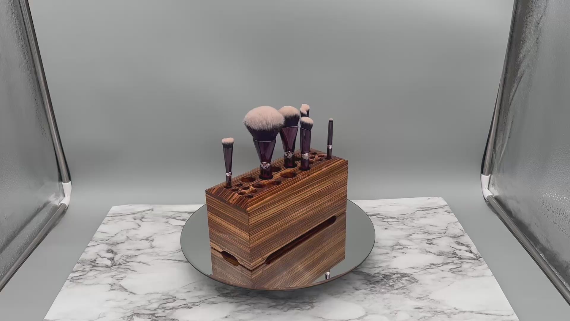 Video of a Zebrawood makeup storage box rotating on a leather round platform on a marble base
